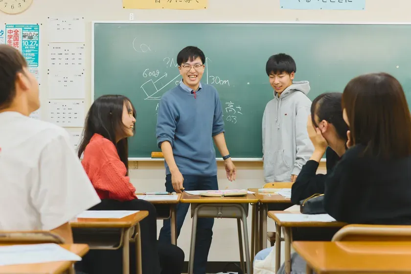 授業中の教室で、先生と生徒が楽しそうに話している様子