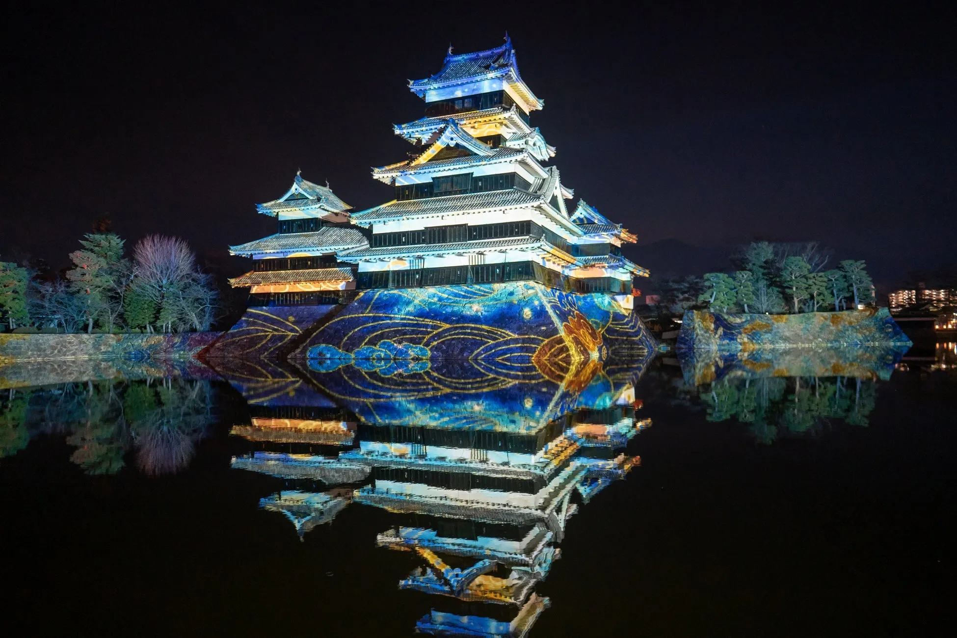 夜の松本城のライトアップ、水面反射