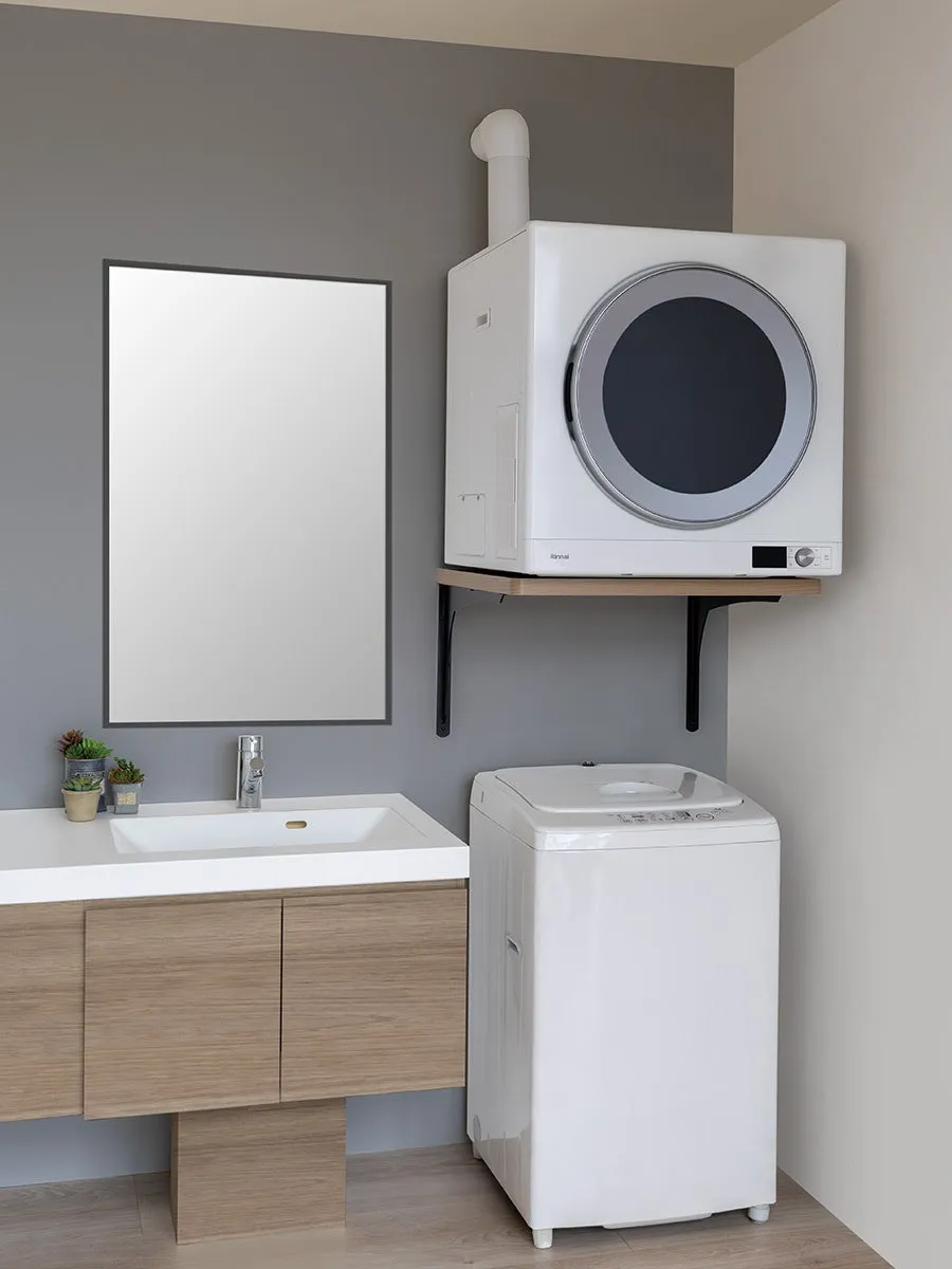 洗面所に設置された洗濯機と乾燥機、鏡と洗面台が写っている写真です。