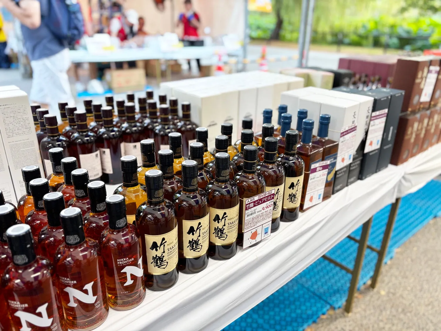 テーブルの上に並べられた様々な種類のウイスキーのボトルが写っている写真。ボトルはラベルが異なり、ブランドや種類が異なることを示唆している。