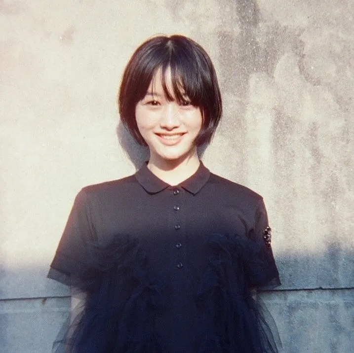 若い女性,笑顔,ショートヘア,黒い服,ポロシャツ,ポートレート,屋外,自然光,壁,カジュアル