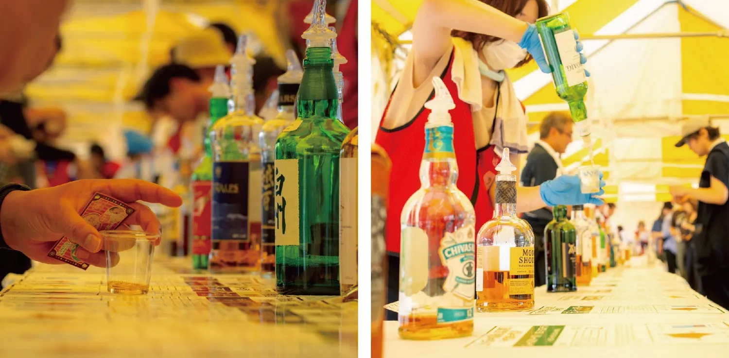 酒のテイスティングイベントの様子。様々な種類の酒が並べられ、参加者がテイスティングを行っている。