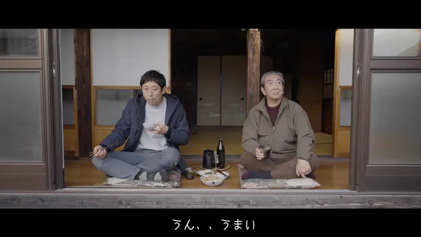 食事をしながらくつろいでいる二人の男性