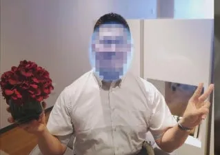 男性が花を持ってピースサインをしている写真です。