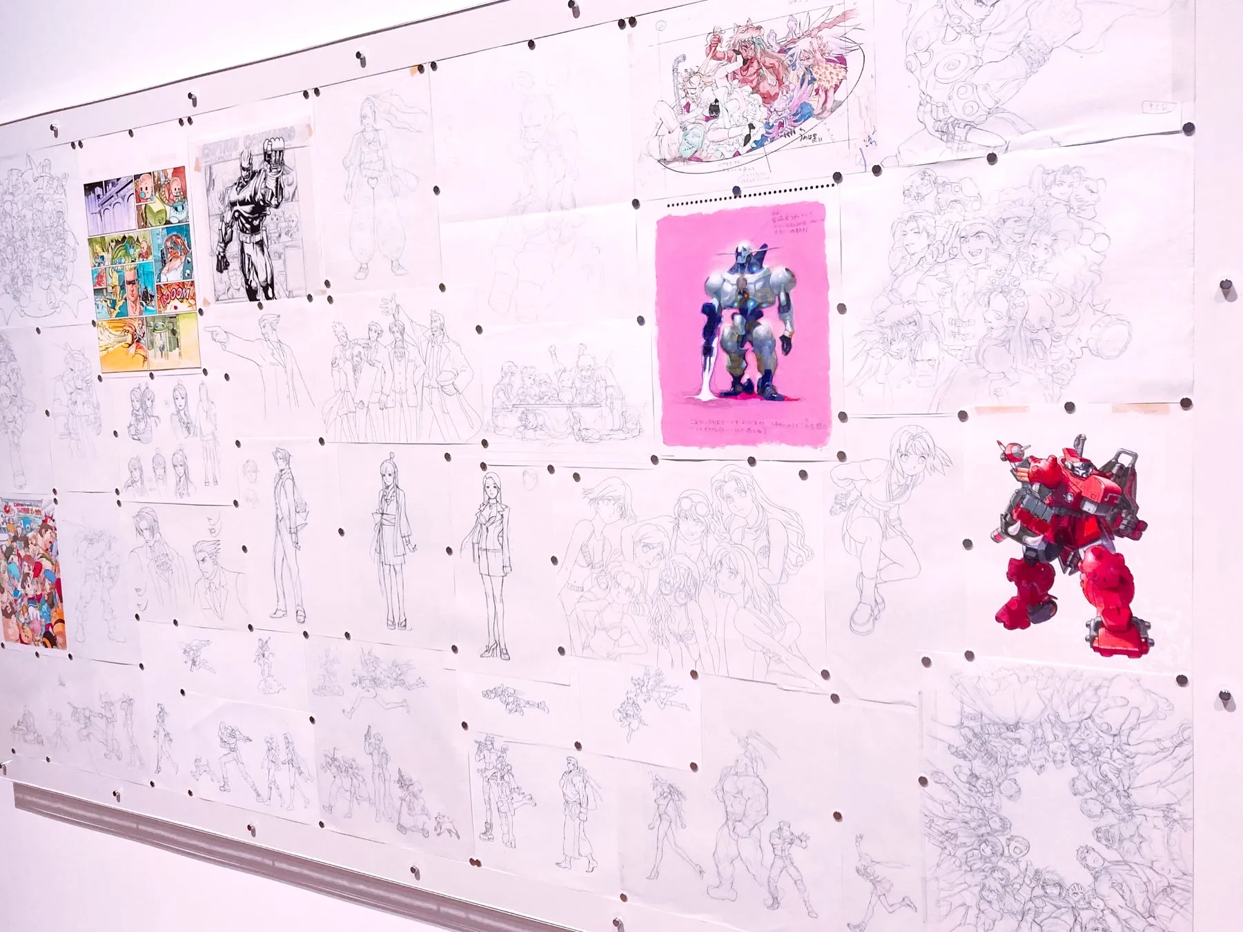 壁に展示されたアニメのイラストやスケッチ