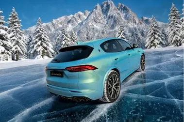 雪山を背景に、水色のマセラティのSUVが氷上に停車している様子