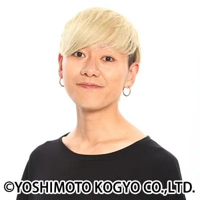 金髪の男性のポートレート写真。彼は黒いシャツを着ていて、笑顔を浮かべている。