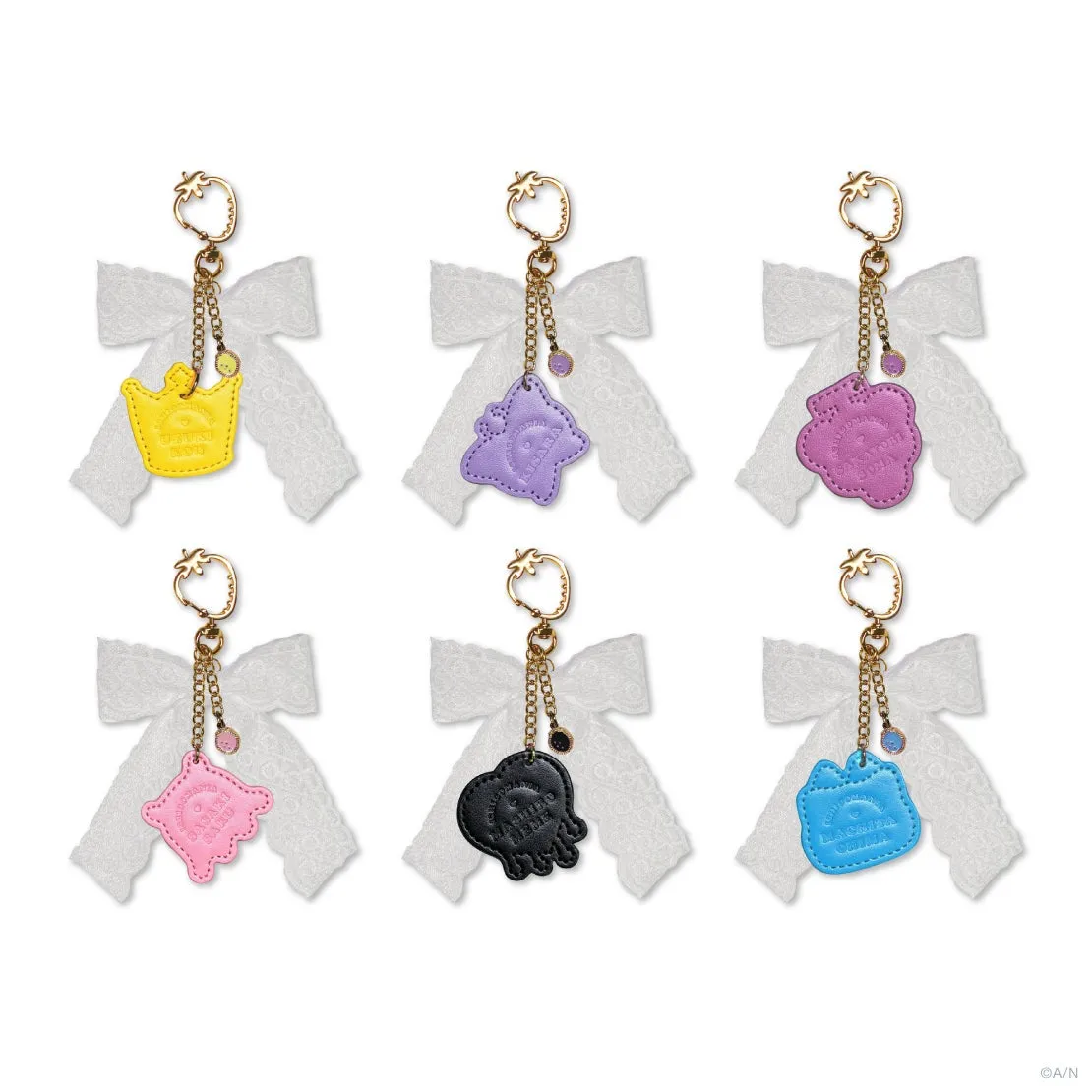 キーホルダーが6つ並んだ写真。それぞれ異なる色とデザインで、リボンとチェーンが付いている.