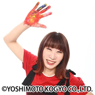 絵の具で手がカラフルに塗られた女性が微笑んでいる様子。